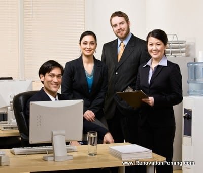 Confident co-workers gathered at desk in office